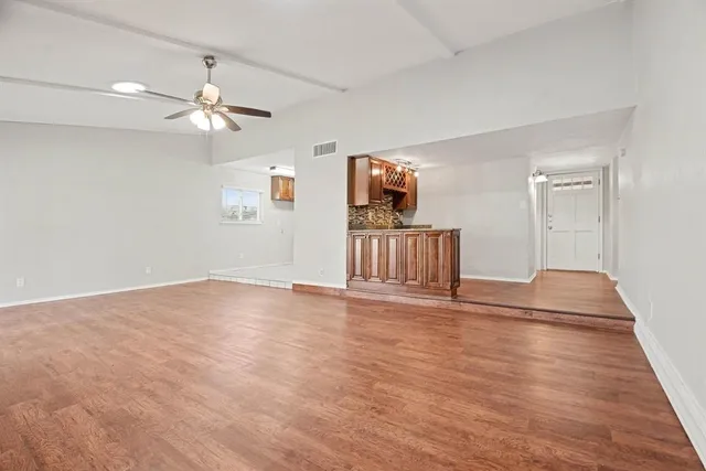 a view of a livingroom with wooden floor and a ceiling fan