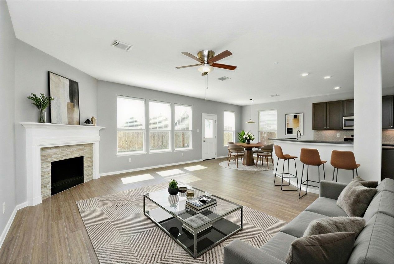 2306 2 Trail Drive Spring, TX 77373 - Photo 4 of 27 This photo showcases a spacious, open-concept living area with modern decor. It features a cozy fireplace, abundant natural light from large windows, and a ceiling fan.