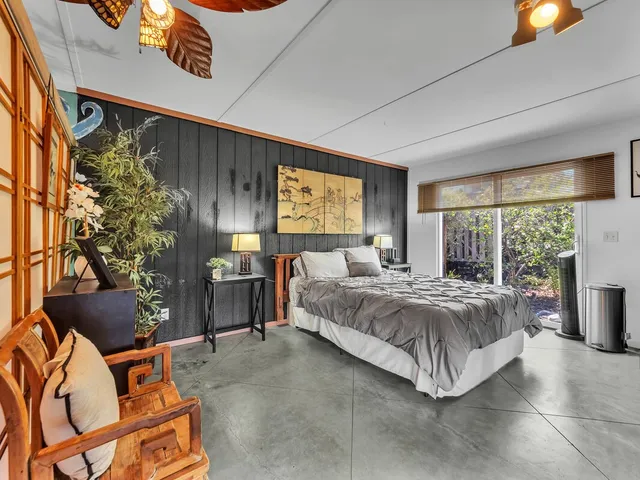 a bedroom with a bed a dresser and a window