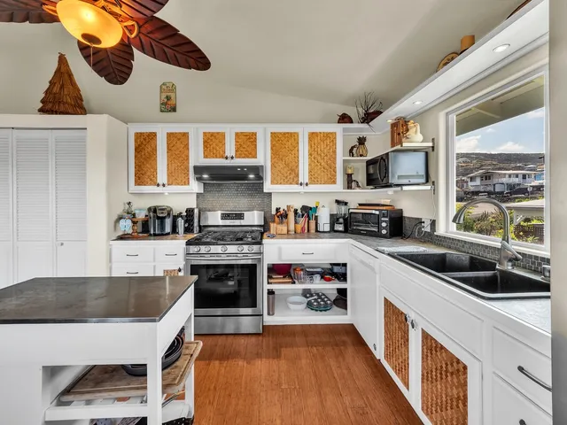 a kitchen with stainless steel appliances granite countertop a stove a sink and a refrigerator