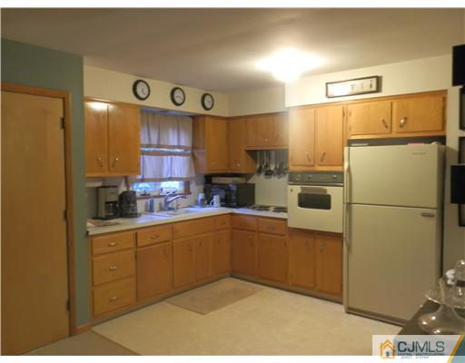 25 Rector Avenue Woodbridge, NJ 07095 - Photo 3 of 14 a kitchen with cabinets a refrigerator and a sink