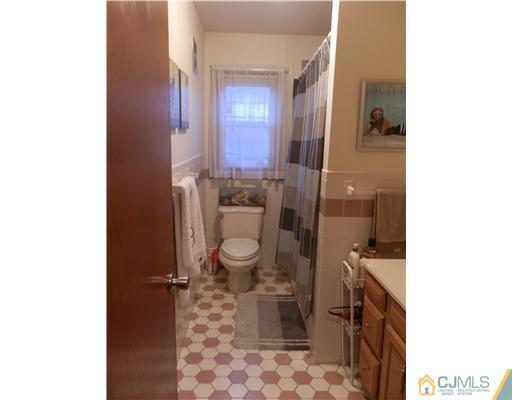 25 Rector Avenue Woodbridge, NJ 07095 - Photo 4 of 14 a bathroom with a toilet and a mirror