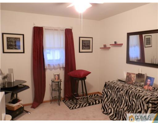 25 Rector Avenue Woodbridge, NJ 07095 - Photo 6 of 14 a bedroom with a bed and a lamp on dresser