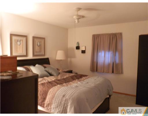 25 Rector Avenue Woodbridge, NJ 07095 - Photo 8 of 14 a bedroom with a bed and a lamp on dresser