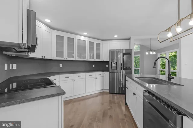 a kitchen with stainless steel appliances granite countertop a refrigerator and a sink