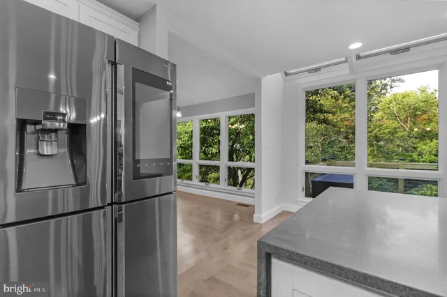 a kitchen with stainless steel appliances granite countertop a sink a stove and a wooden floors