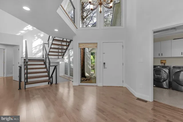a view of a hallway with wooden floor and stairs