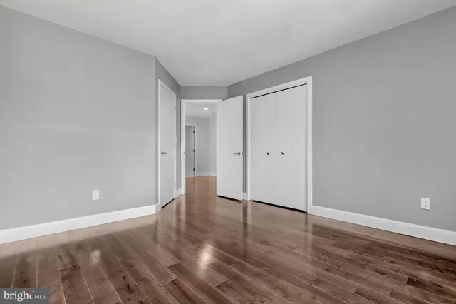 a kitchen with stainless steel appliances kitchen island granite countertop a stove top oven a sink a dining table and chairs with wooden floor