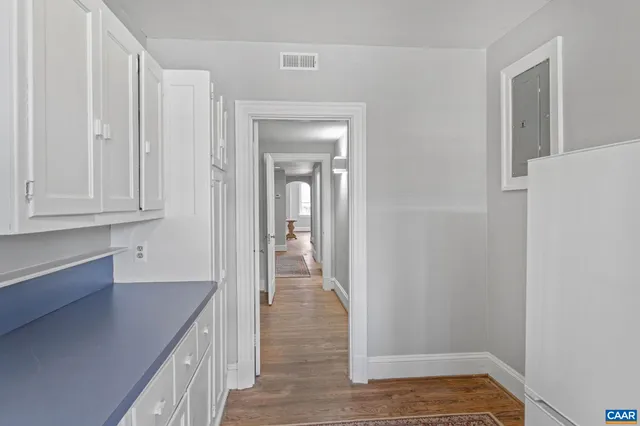 a view of a hallway with wooden floor and staircase