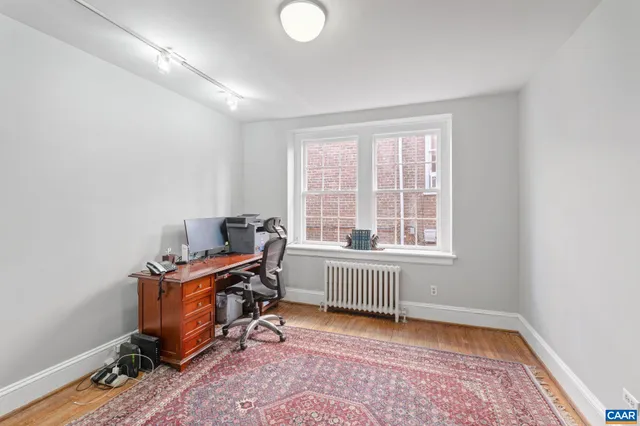a view of a workspace with furniture and a window