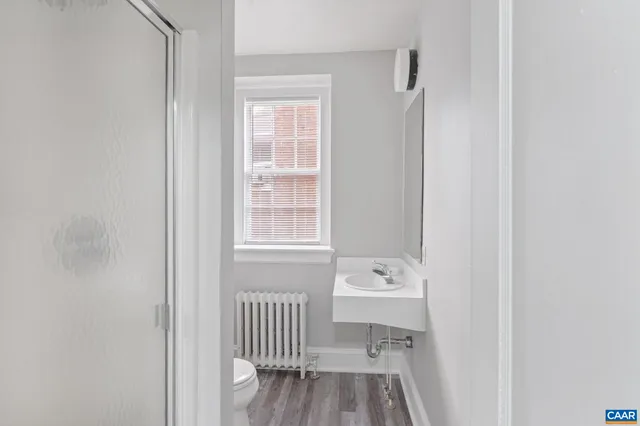 a bathroom with a sink a toilet and a window