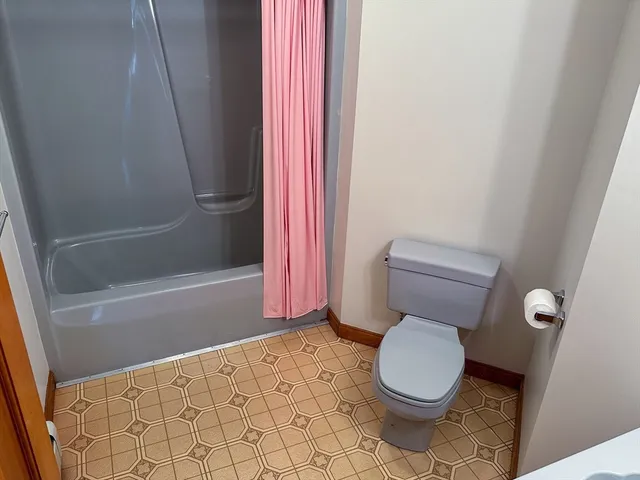 a bathroom with a toilet and a shower