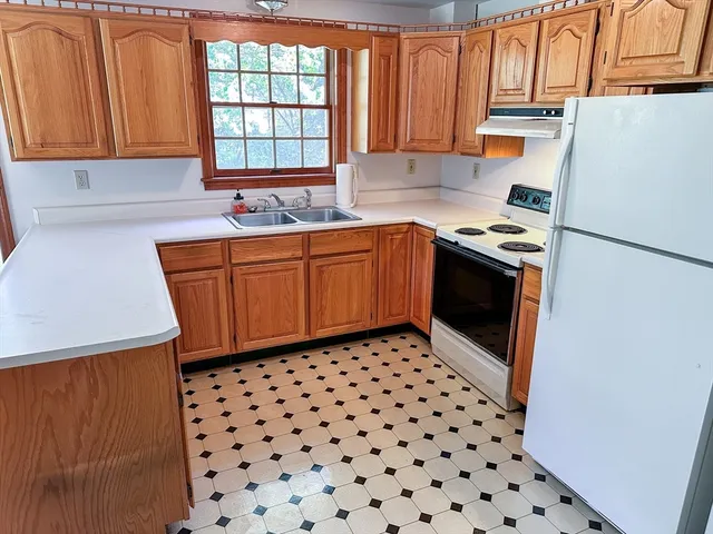 a kitchen with granite countertop a refrigerator a sink a stove a microwave and cabinets