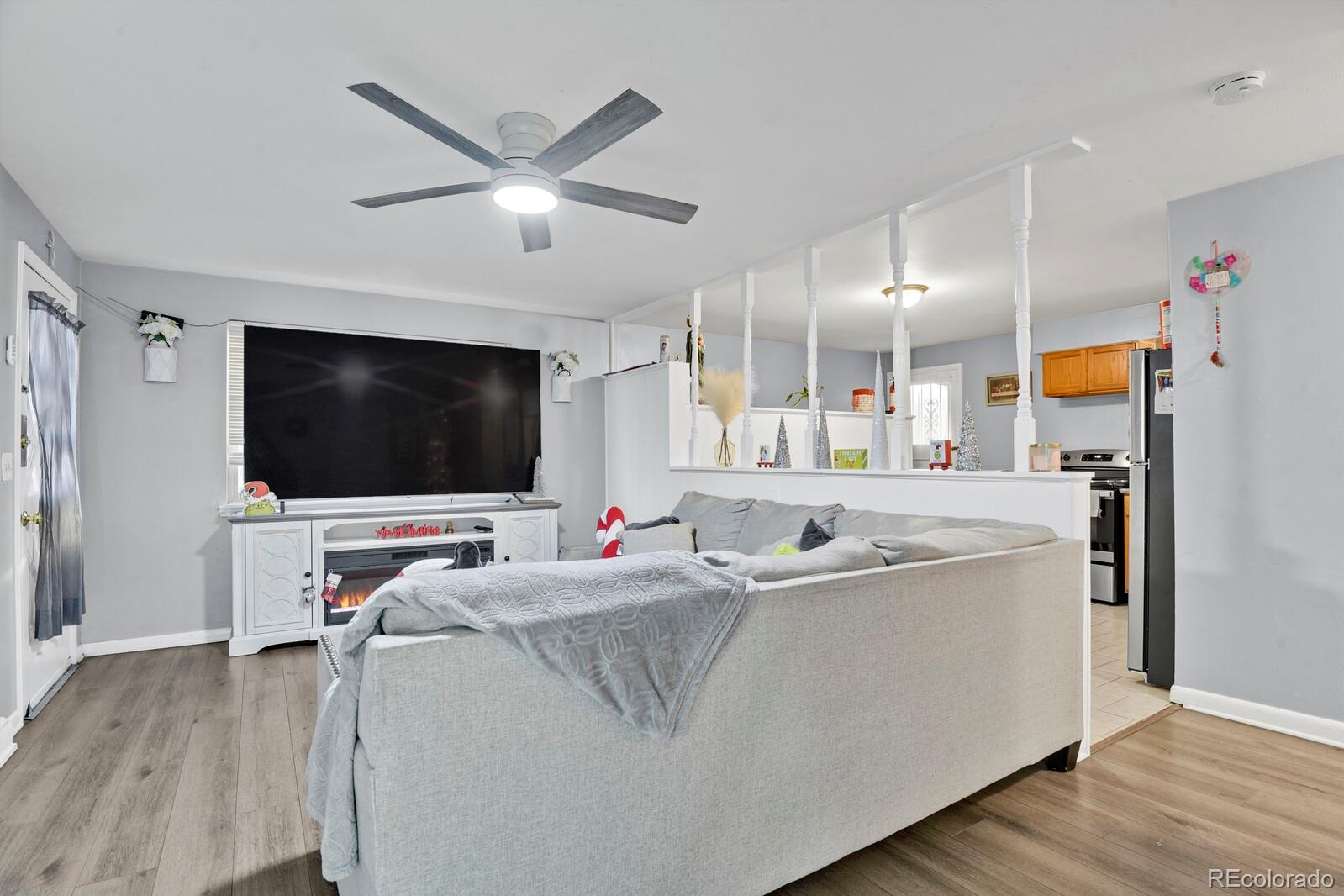233 South Decatur Street Denver, CO 80219 - Photo 21 of 35 a living room with stainless steel appliances kitchen island furniture and a flat screen tv