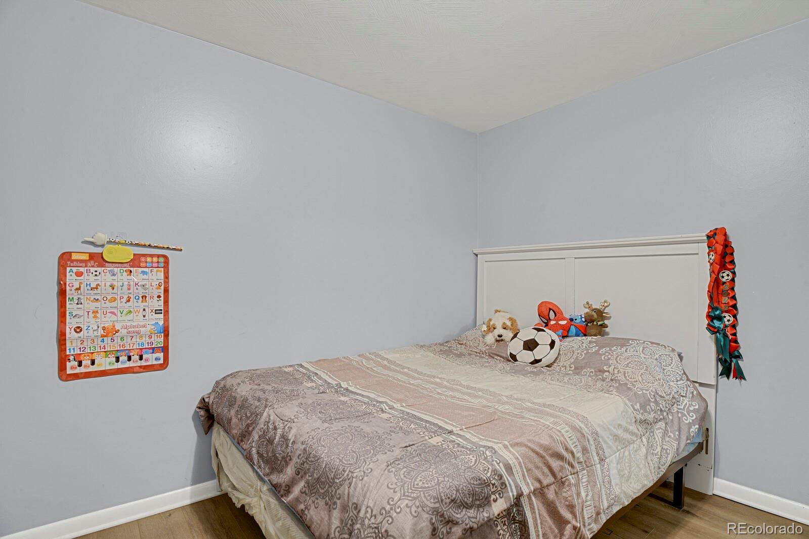 233 South Decatur Street Denver, CO 80219 - Photo 29 of 35 a bedroom with a bed and wooden floor
