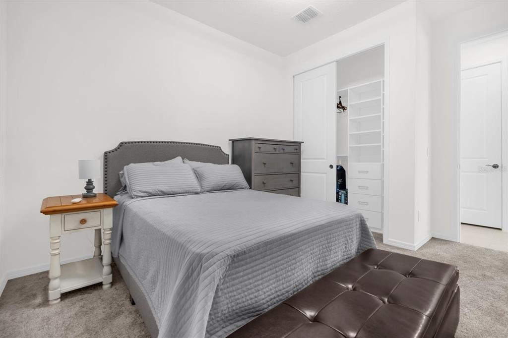 1911 Spring Shower Circle Kissimmee, FL 34744 - Photo 24 of 52 a room with a bed and a lamp on desk