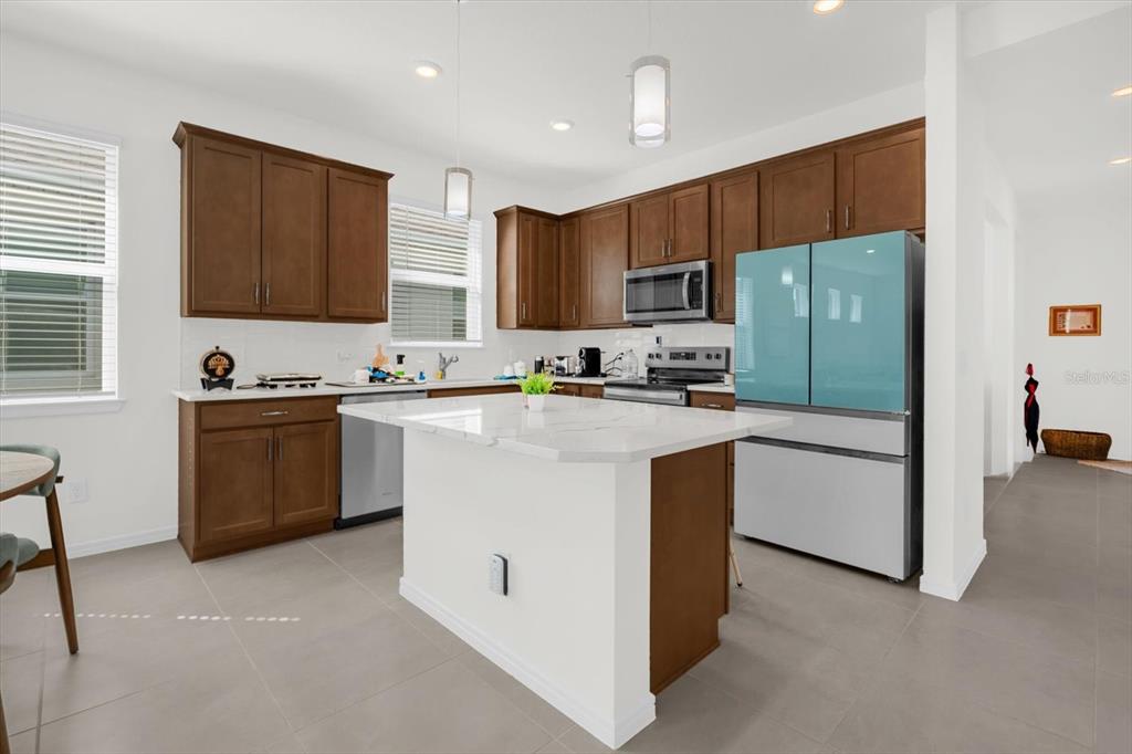 1911 Spring Shower Circle Kissimmee, FL 34744 - Photo 8 of 52 a kitchen with stainless steel appliances granite countertop wooden cabinets a stove a sink and a refrigerator