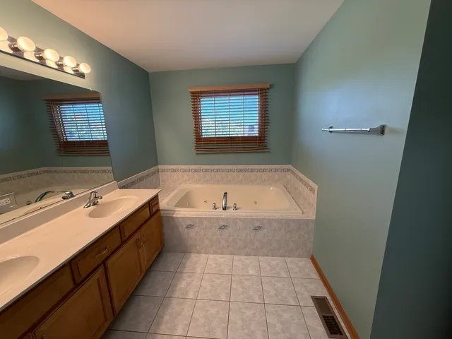 a bathroom with a tub sink and mirror