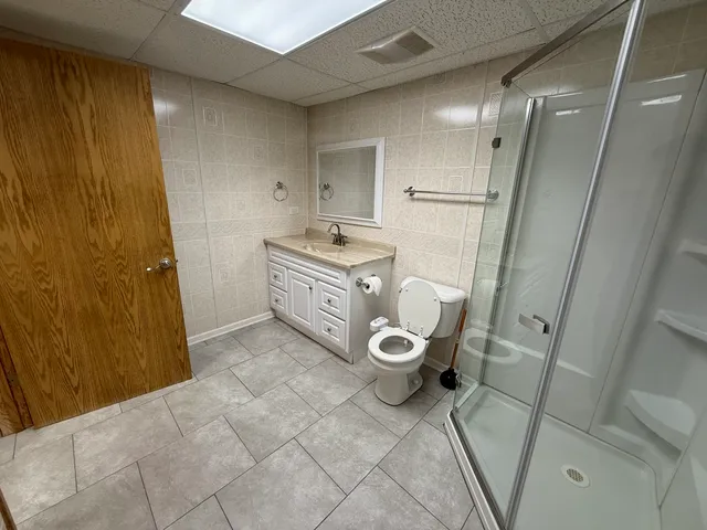 a bathroom with a granite countertop sink toilet and shower