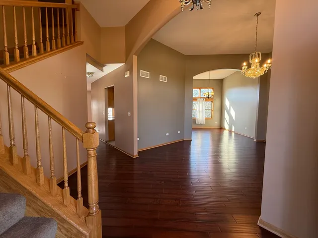 a view of a hallway with wooden floor and staircase