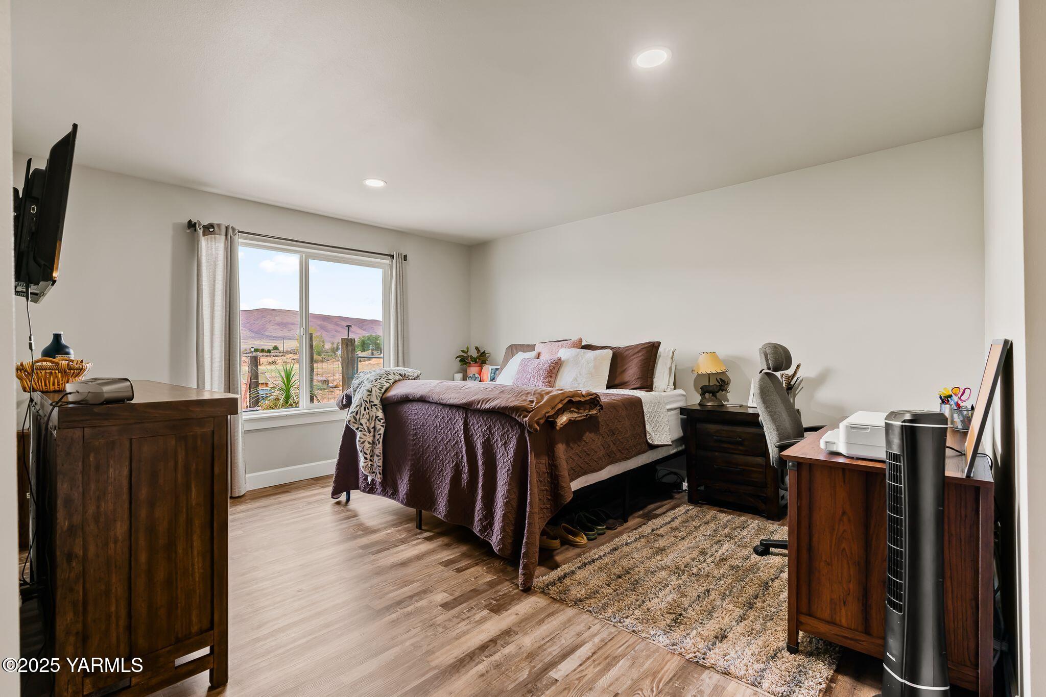 192 Sage Cove Road Yakima, WA 98903 - Photo 11 of 33 a spacious bedroom with a bed and wooden floor