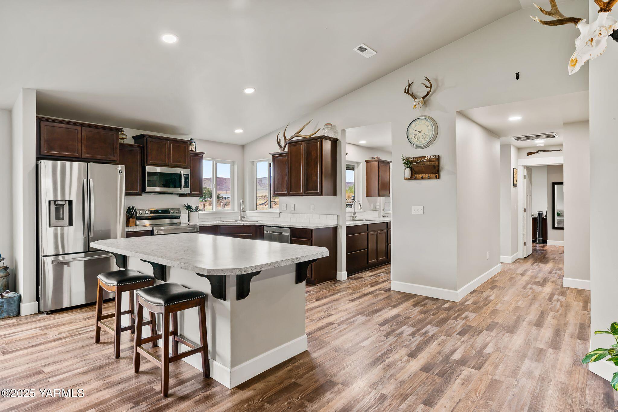192 Sage Cove Road Yakima, WA 98903 - Photo 5 of 33 a large kitchen with stainless steel appliances kitchen island granite countertop a refrigerator and a stove top oven