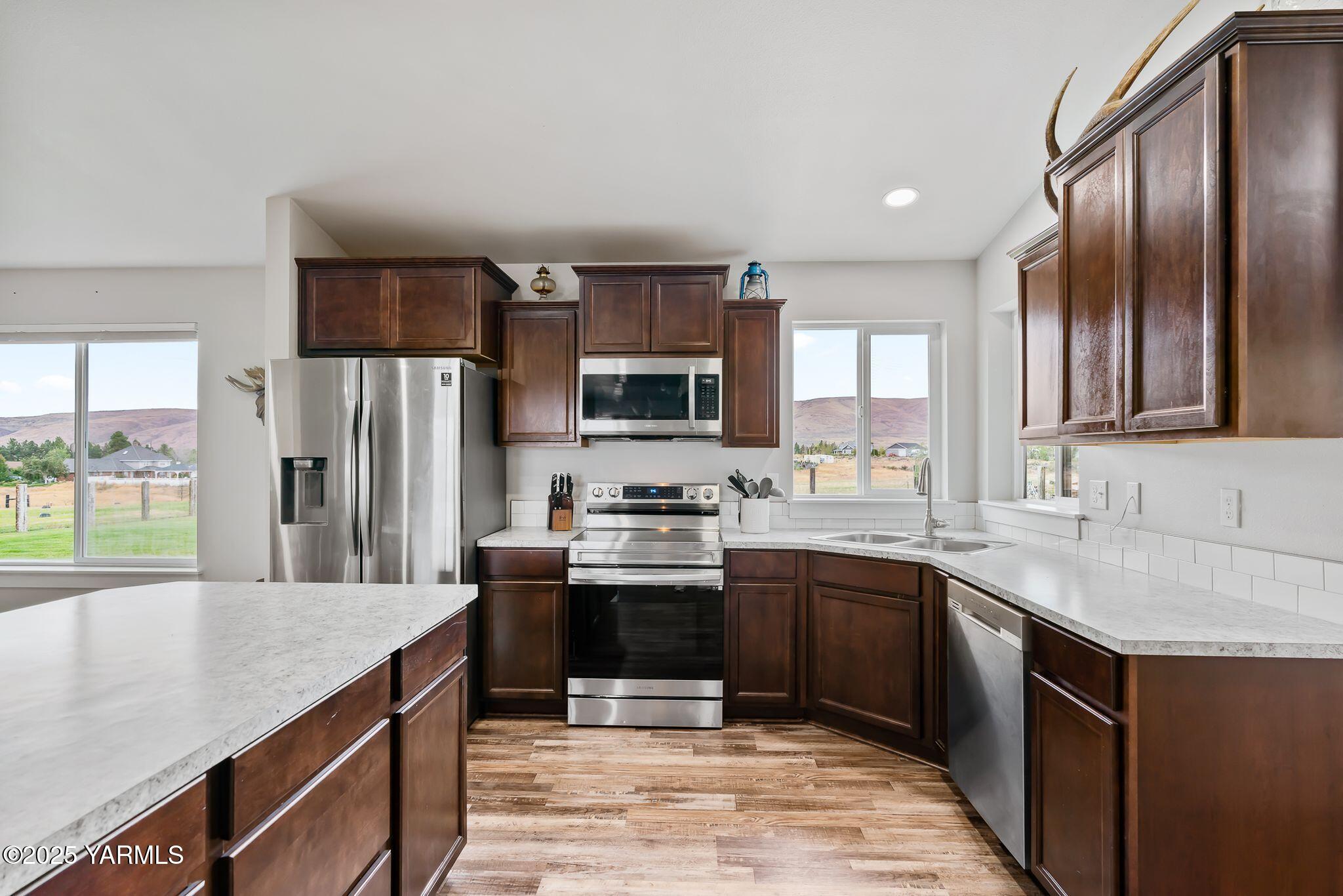 192 Sage Cove Road Yakima, WA 98903 - Photo 6 of 33 a kitchen with stainless steel appliances granite countertop a sink stove microwave and refrigerator