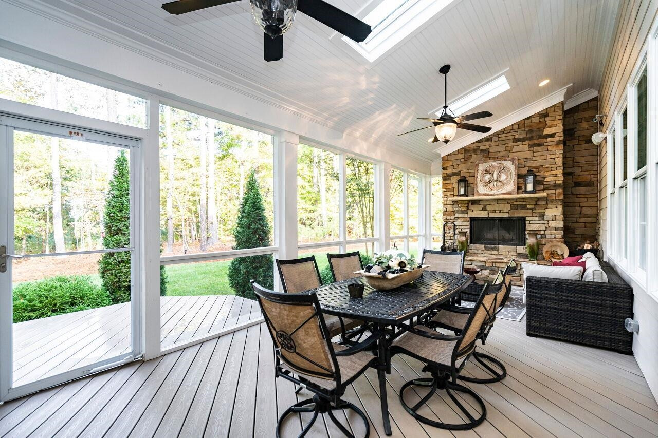 8401 Bournemouth Drive Raleigh, NC 27615 - Photo 37 of 41 Screen Porch with vaulted ceiling, skylights, two ceiling fans, stone surround and hearth wood burning fireplace and trek flooring. Screen Porch