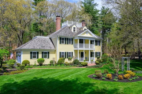 a front view of a house with a yard and green space