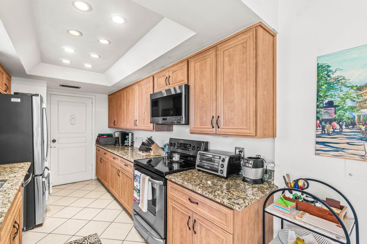 2000 South Ocean Boulevard, Unit 306 Delray Beach, FL 33483 - Photo 11 of 42 a kitchen with stainless steel appliances granite countertop a stove a sink and a microwave