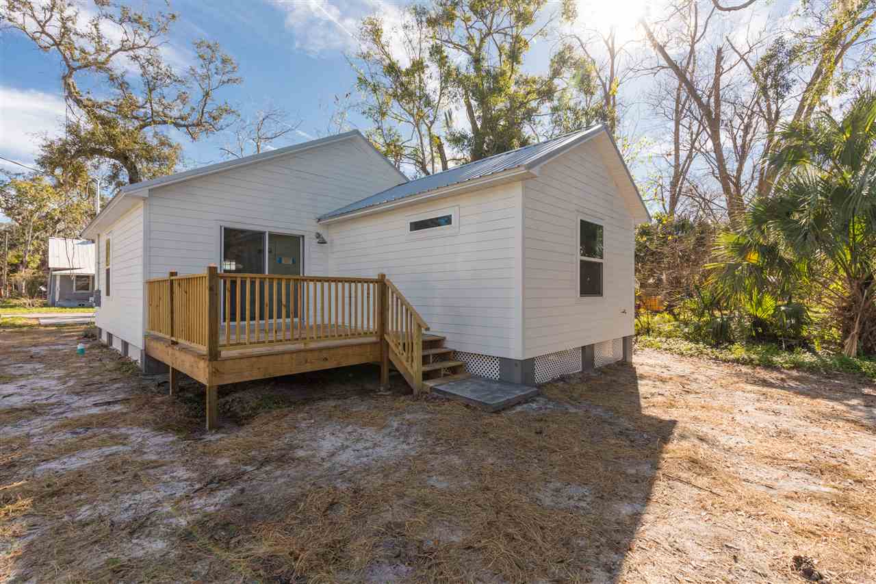 201 Spring Street St. Augustine, FL 32084 - Photo 15 of 18 a view of a small house with a yard and wooden fence