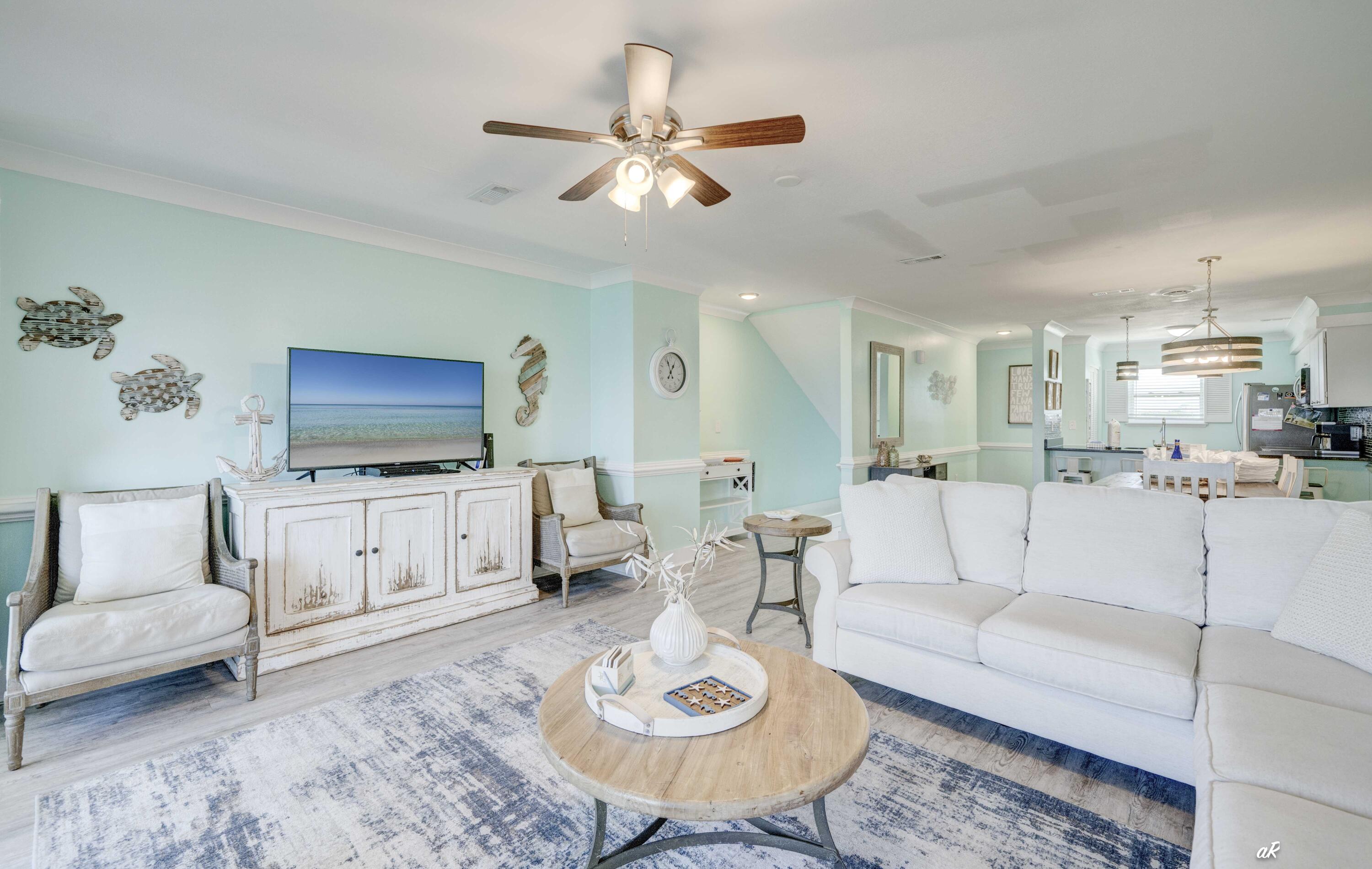 3869 Cape San Blas Road Port St. Joe, FL 32456 - Photo 14 of 52 a living room with furniture a flat screen tv and a chandelier