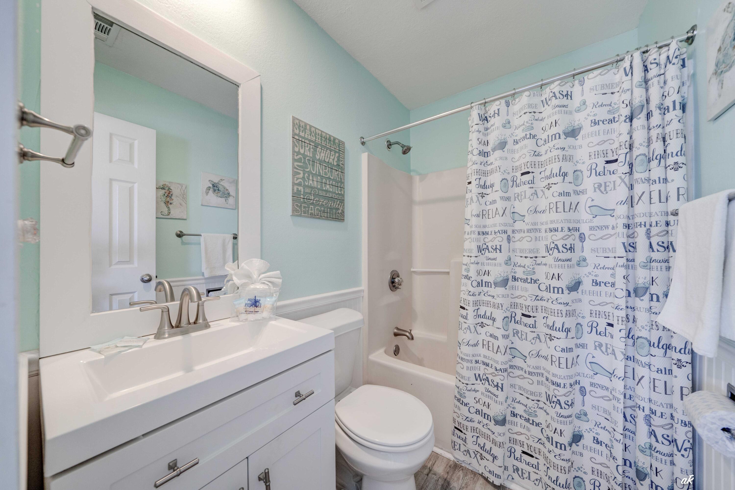 3869 Cape San Blas Road Port St. Joe, FL 32456 - Photo 36 of 52 a bathroom with a sink a toilet and shower curtain
