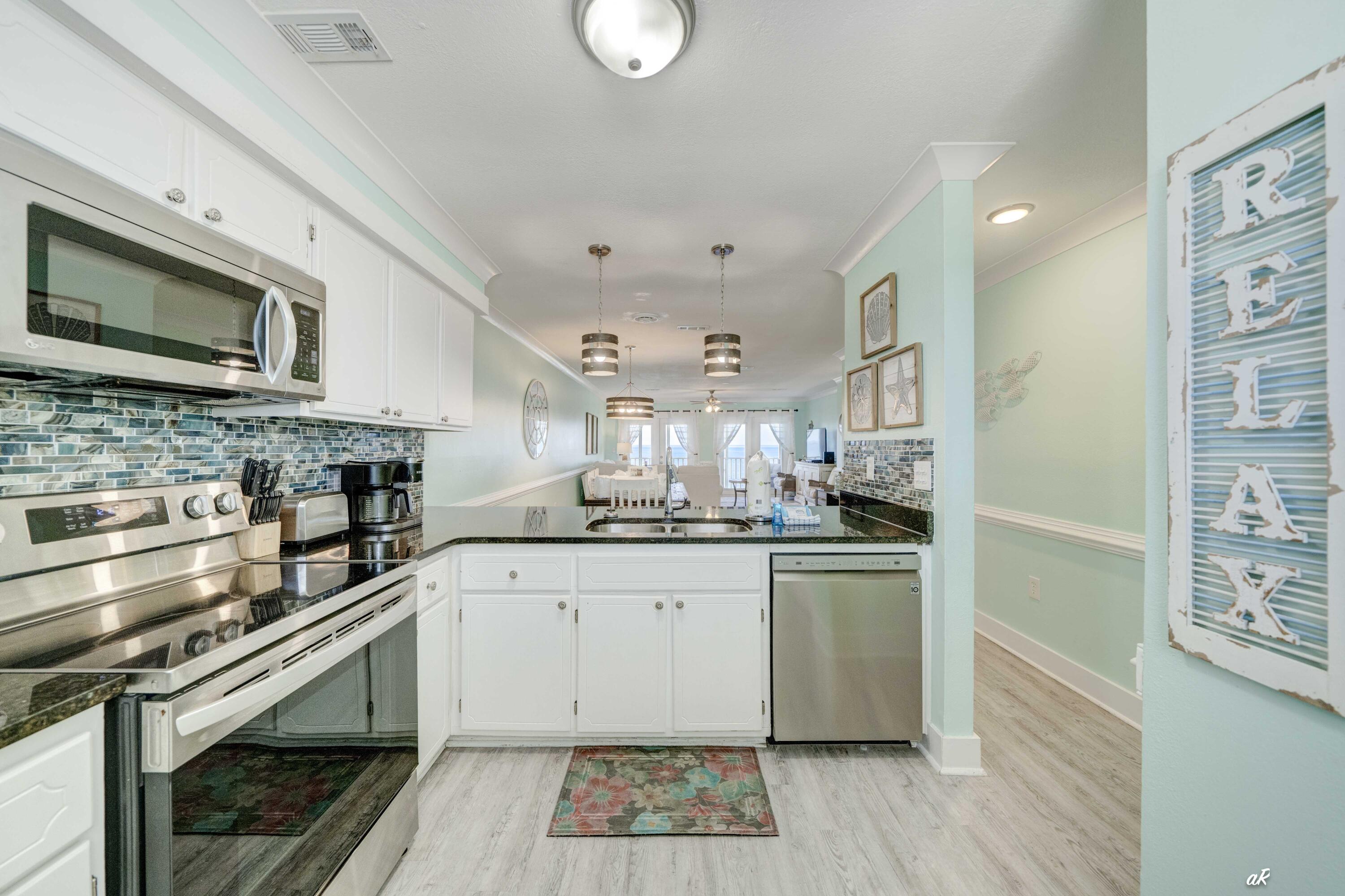 3869 Cape San Blas Road Port St. Joe, FL 32456 - Photo 7 of 52 a kitchen with stainless steel appliances granite countertop a stove and a microwave