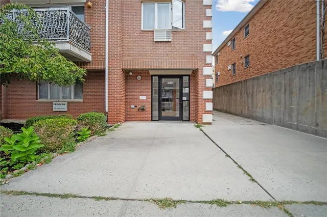 a couple of potted plants in front of brick building