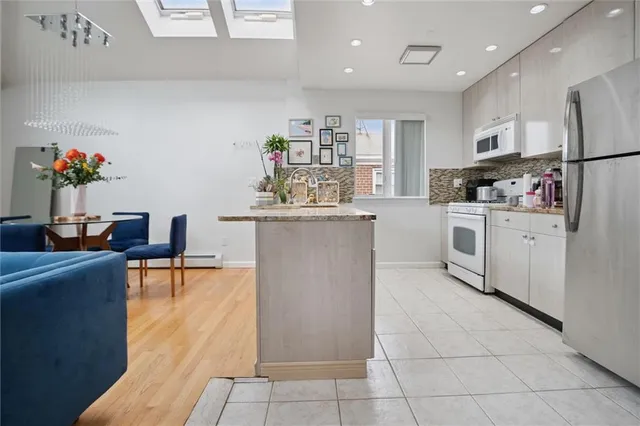a kitchen with stainless steel appliances granite countertop a refrigerator and a stove top oven