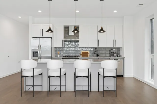 a kitchen with appliances and chairs