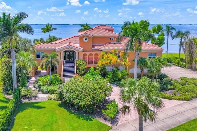 a front view of a house with a yard and potted plants