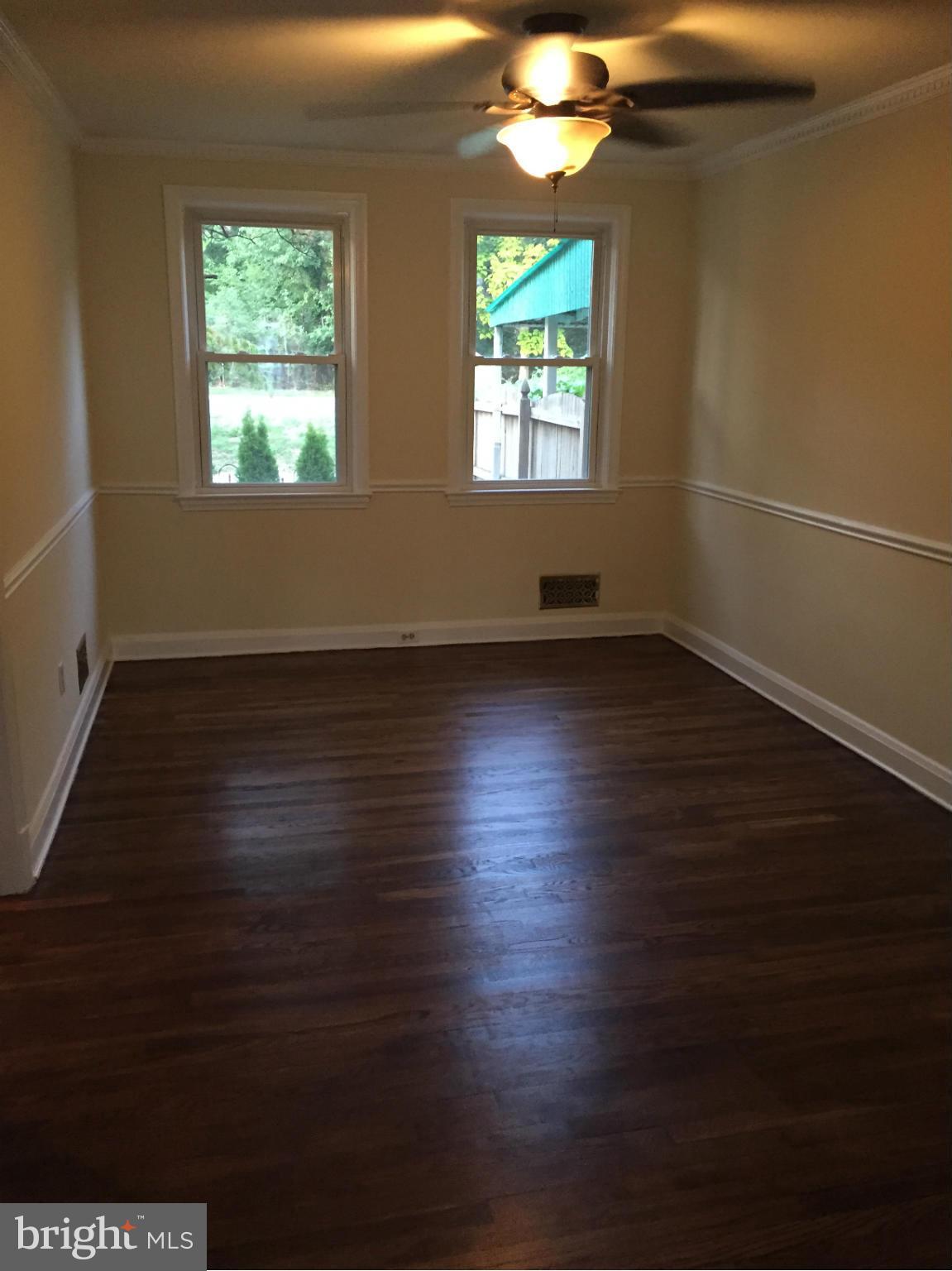 1616 Thetford Road Towson, MD 21286 - Photo 4 of 13 an empty room with wooden floor and windows