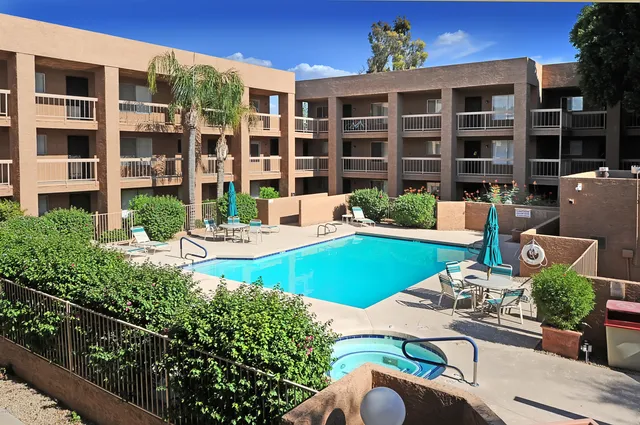 a view of a patio with couches table and chairs and potted plants