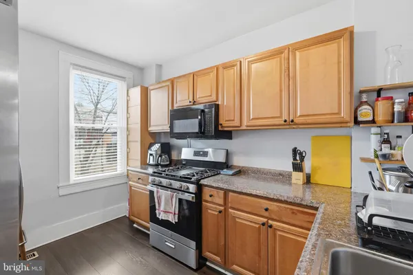 a kitchen with stainless steel appliances granite countertop a refrigerator and a stove