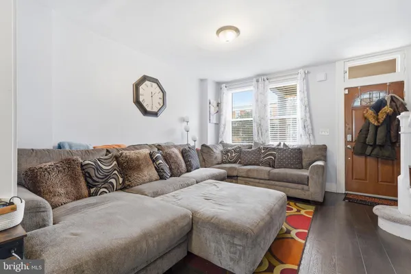 a living room with furniture a flat screen tv and a window