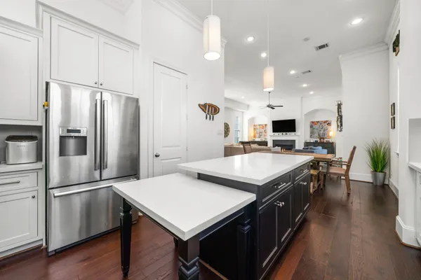a open kitchen with stainless steel appliances granite countertop a table chairs and a refrigerator