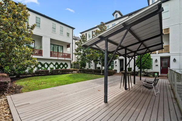 a view of a patio with a table and chairs under an umbrella with a wooden floor