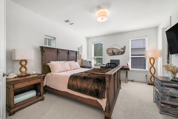 a living room with a bed furniture flat screen tv and window