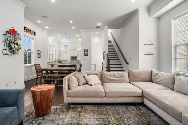 a living room with furniture kitchen view and a window