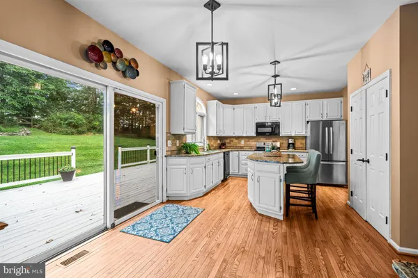 a kitchen with kitchen island granite countertop a sink and a refrigerator