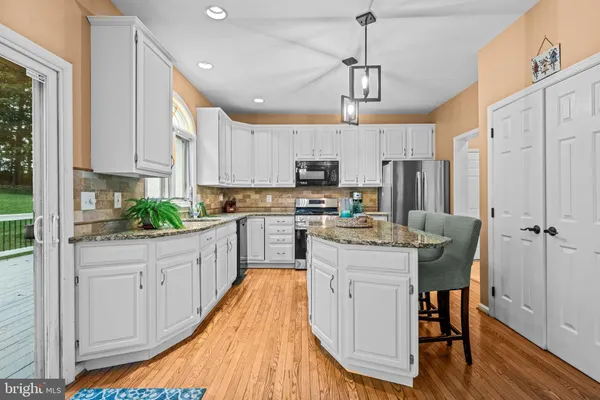 a bathroom with a granite countertop toilet a sink and a mirror
