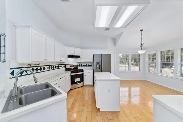 a kitchen with a sink stove and cabinets
