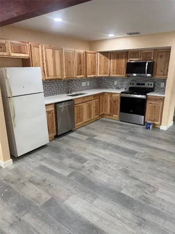 a kitchen with stainless steel appliances granite countertop a stove top oven a sink and a granite counter tops